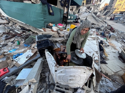 Palestinian Umm Nael Al-Khlout cooks breakfast on the rubble of her house which was destroyed during Israel's military offensive in Beit Lahia in the northern Gaza Strip on March 13.