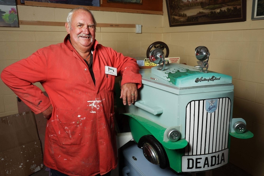 "Coffin club" member Kevin Heyward poses next to a coffin he built to resemble a hot rod. It's a task of grave importance, but there's nothing to stop New Zealanders having a laugh as they work on DIY caskets in the country's coffin clubs.