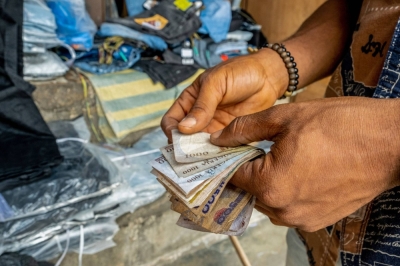 Nigerian naira being counted in Lagos, Nigeria. Cash transfers offer a transformative solution to multidimensional poverty.