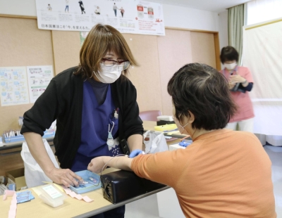 A woman undergoes a blood test in Fuchu, Tokyo, for research on the impact of per- and polyfluoroalkyl substances.
