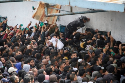 Palestinians gather to receive aid outside an UNRWA warehouse as Gaza residents face crisis levels of hunger on Monday.