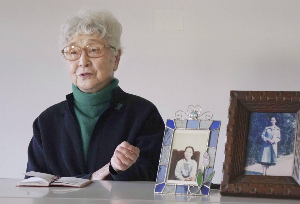 Sakie Yokota, whose daughter, Megumi, was abducted by North Korea at age 13 in 1977, speaks in an interview in Kawasaki, Kanagawa Prefecture, on Feb. 20 with photos of Megumi and Kim Eun Gyong, Megumi's daughter, by her side.