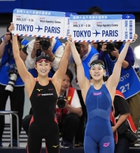 Swimmers Rikako Ikee (left) and Mizuki Hirai celebrate after earning spots at the Paris Olympics in the women's 100-meter butterfly at the qualifying trials at Tokyo Aquatics Centre on Monday. | Kyodo