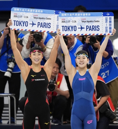 Swimmers Rikako Ikee (left) and Mizuki Hirai celebrate after earning spots at the Paris Olympics in the women's 100-meter butterfly at the qualifying trials at Tokyo Aquatics Centre on Monday.
