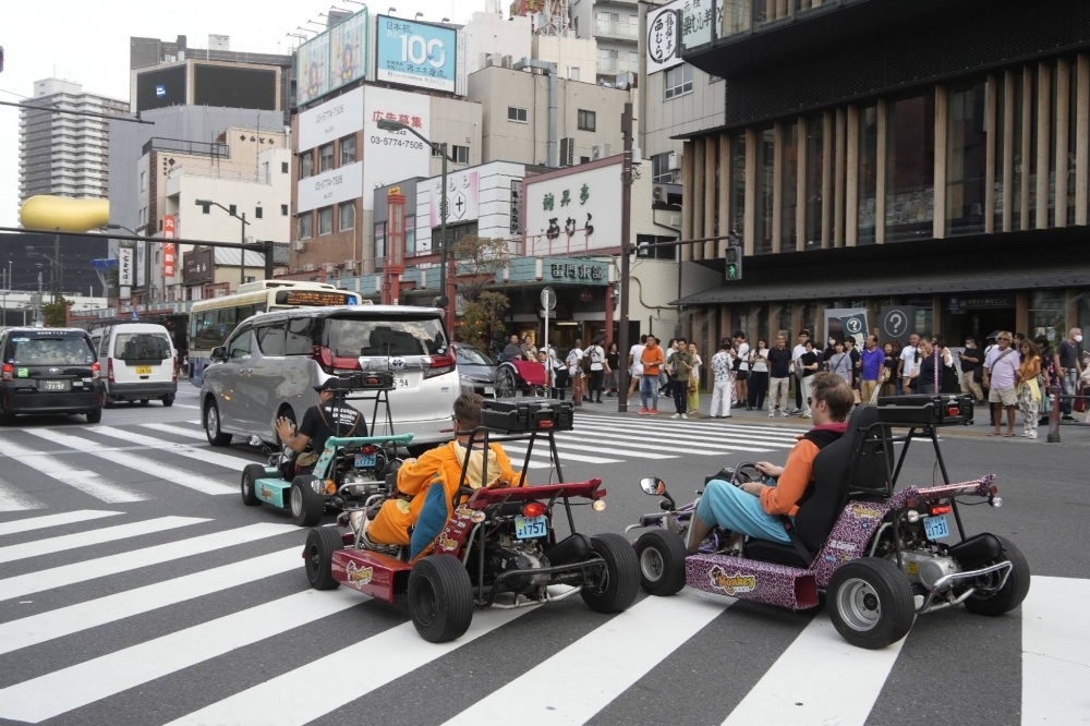 Tourists ride go-karts on a street in Tokyo's Asakusa area in October.