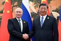 Russian President Vladimir Putin shakes hands with Chinese President Xi Jinping during a meeting at the Belt and Road Forum in Beijing in October last year. | Sputnik / Pool / via REUTERS 