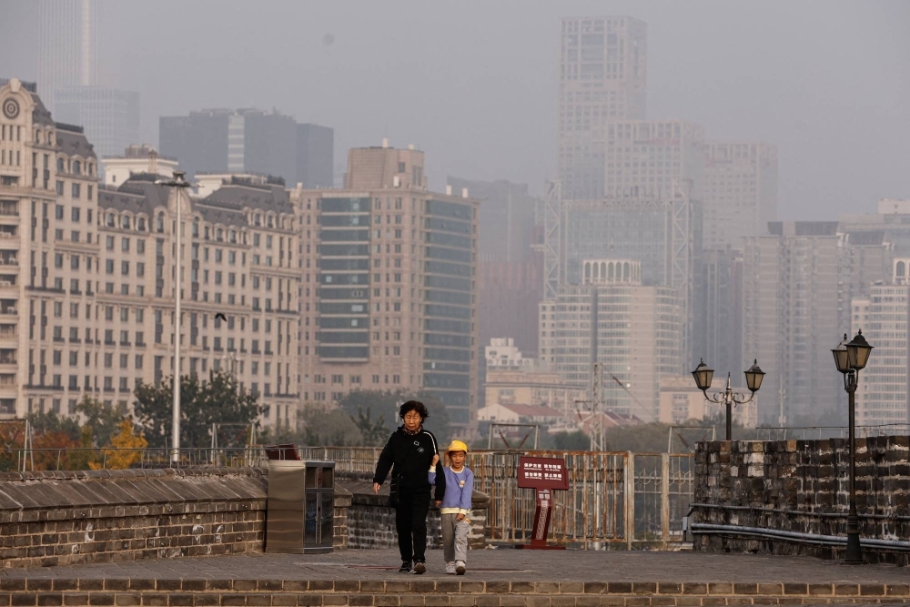 People walk along the Ming Dynasty City Wall Relics Park in Beijing. People walk along the Ming Dynasty City Wall Relics Park in Beijing.