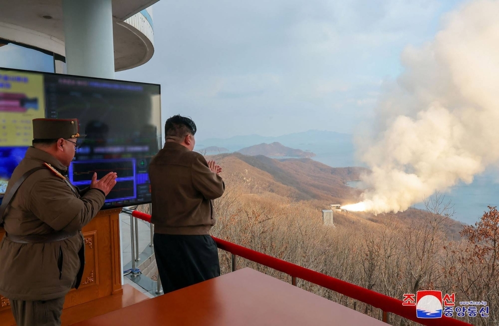 North Korean leader Kim Jong Un observs a ground test of a solid fuel engine for a new intermediate-range hypersonic missile, at the Sohae Satellite Launching Ground on North Korea’s western coast in this digitally altered image released Wednesday.