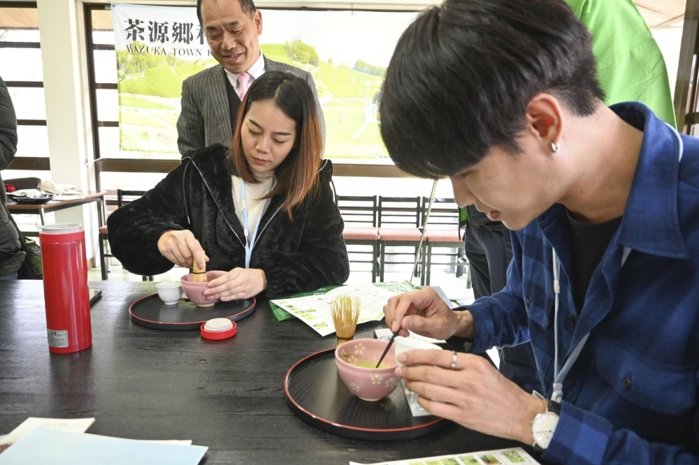 Travel agents from Thailand make matcha tea in the town of Wazuka, Kyoto Prefecture, on Feb. 27, during a tourism promotion program organized by the Kansai Bureau of the Ministry of Economy, Trade and Industry.