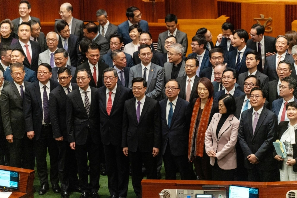 Hong Kong leader John Lee (center) with lawmakers after they passed the city's new security law. Hong Kong has fast-tracked into law domestic security legislation that critics say could muzzle open economic discussion and tighten control over foreign bodies operating in the global finance hub.