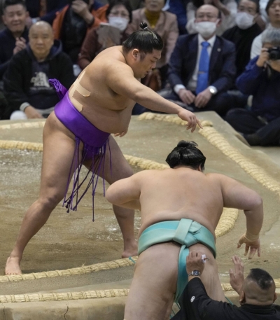 No. 17 maegashira Takerufuji (top) forces out ozeki Kotonowaka on Day 11 of the Spring Grand Sumo Tournament at Edion Arena Osaka in Osaka on Wednesday.