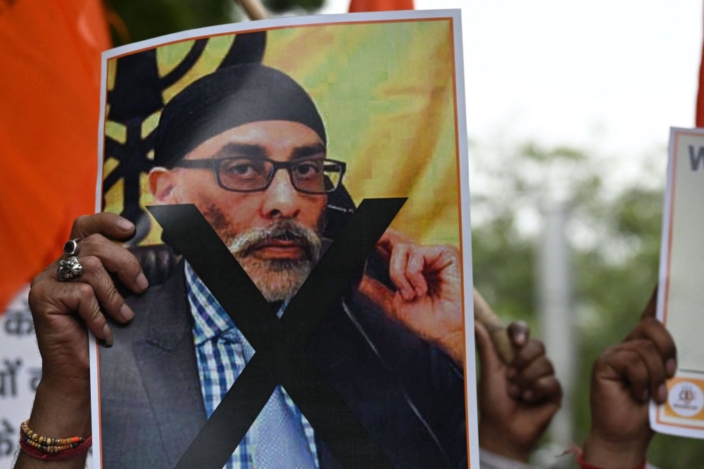A protester in New Delhi holds a banner depicting Gurpatwant Singh Pannun, who has said he was the target of an assassination plot disclosed by U.S. prosecutors in November 2023.