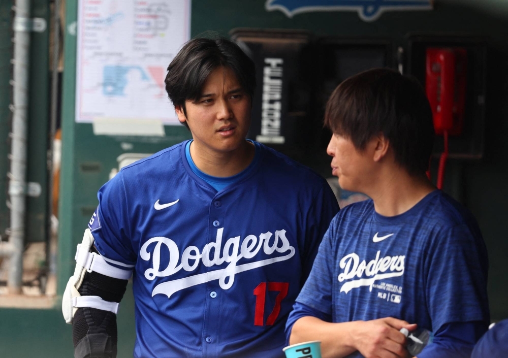 Dodgers designated hitter Shohei Ohtani talks with interpreter Ippei Mizuhara during a spring training game in Phoenix on March 12.