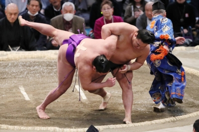 Takerufuji (left) is thrown to the ground by Hoshoryu on Thursday during the Spring Grand Sumo Tournament in Osaka. 