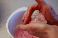 Keeping a bowl of the water used earlier in this recipe will help keep your hands clean when forming rice balls. | ELIZABETH ANDOH
