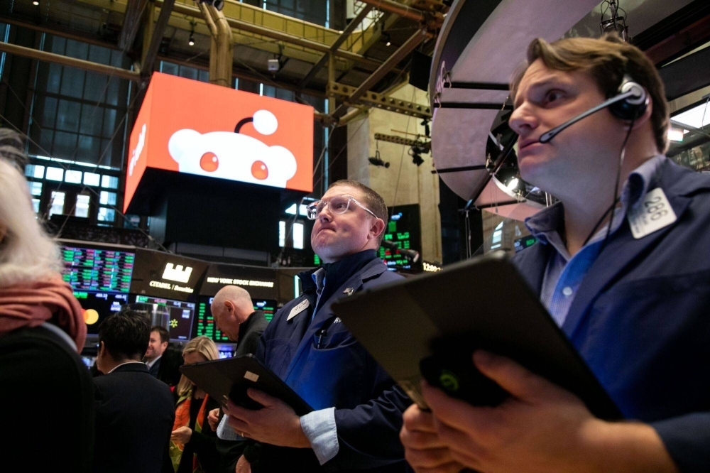 Traders work on the floor of the New York Stock Exchange on Thursday during the Reddit initial public offering.
