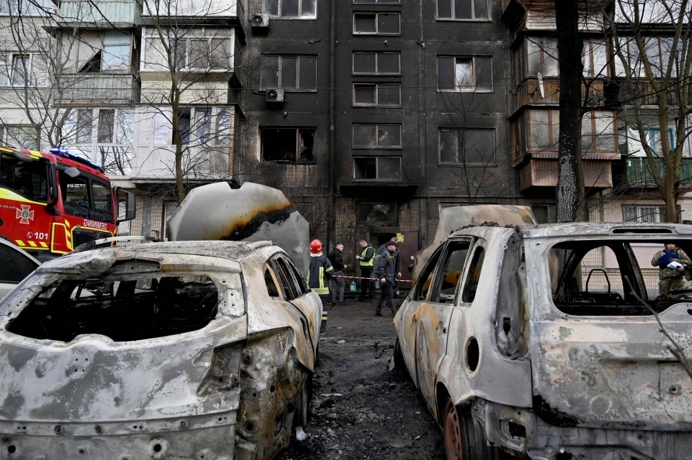 Ukrainian rescuers gather outside of a residential building after a missile attack in Kyiv on Thursday. 