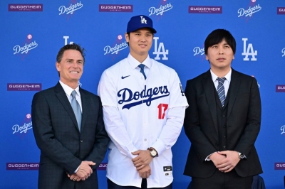 Baseball player Shohei Ohtani poses with his Japanese interpreter, Ippei Mizuhara (right), and his agent, Nez Balelo, during a news conference after signing a 10-year deal with the Los Angeles Dodgers last year.