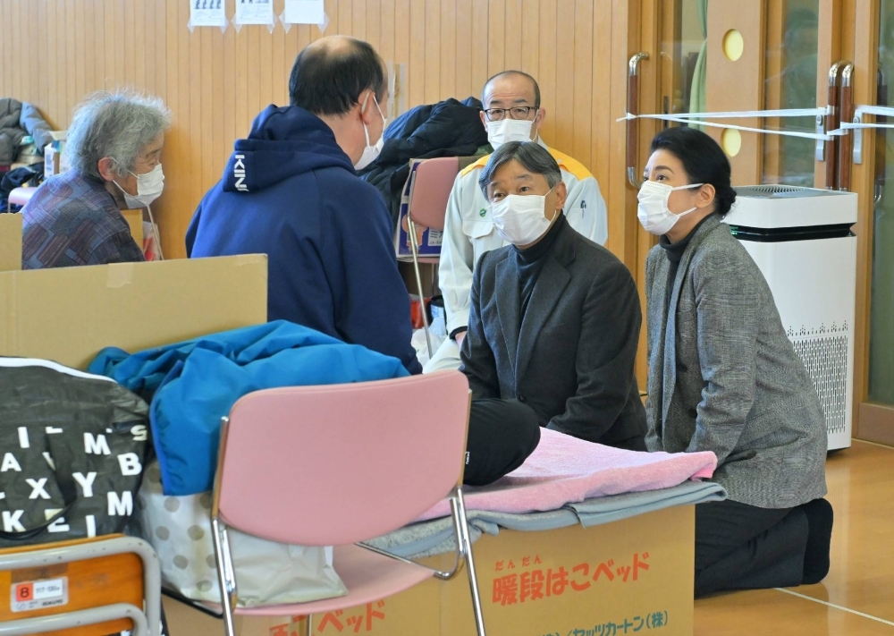 Emperor Naruhito and Empress Masako speak to evacuees at an evacuation shelter in Wajima, Ishikawa Prefecture, on Friday.