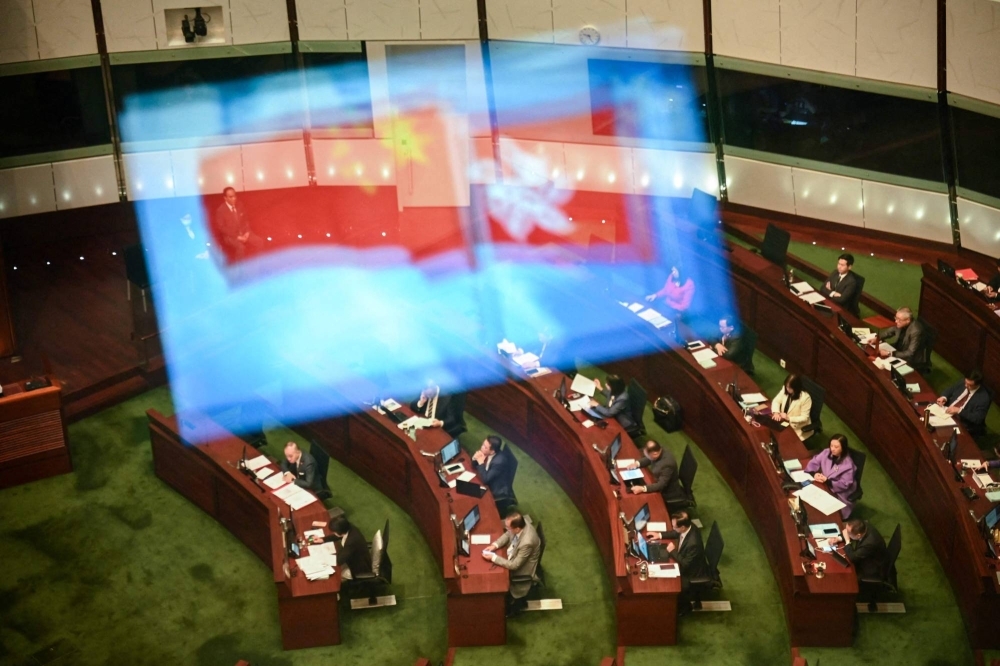 A view of the Legislative Council chamber with Chinese and Hong Kong flags reflected on the window is seen as the second reading of the Article 23 security law is read, in Hong Kong on Tuesday.