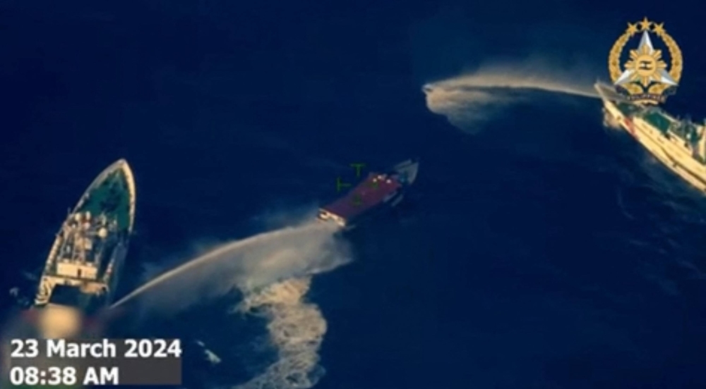 A screenshot from a video taken and released Saturday shows China Coast Guard ships deploying water cannons against a Philippine military-chartered civilian supply boat near the Second Thomas Shoal in disputed waters of the South China Sea.