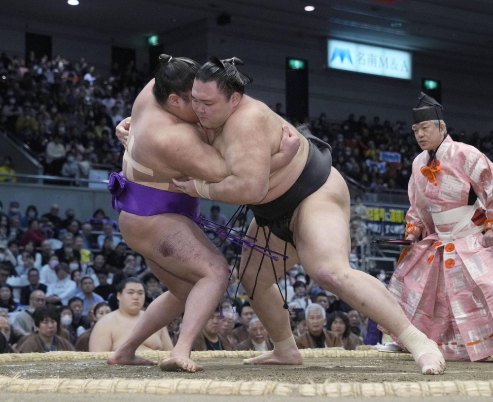 Asanoyama (right) defeats top-division debutant Takerufuji, ensuring that the title in Osaka comes down to the final day on Sunday. 
