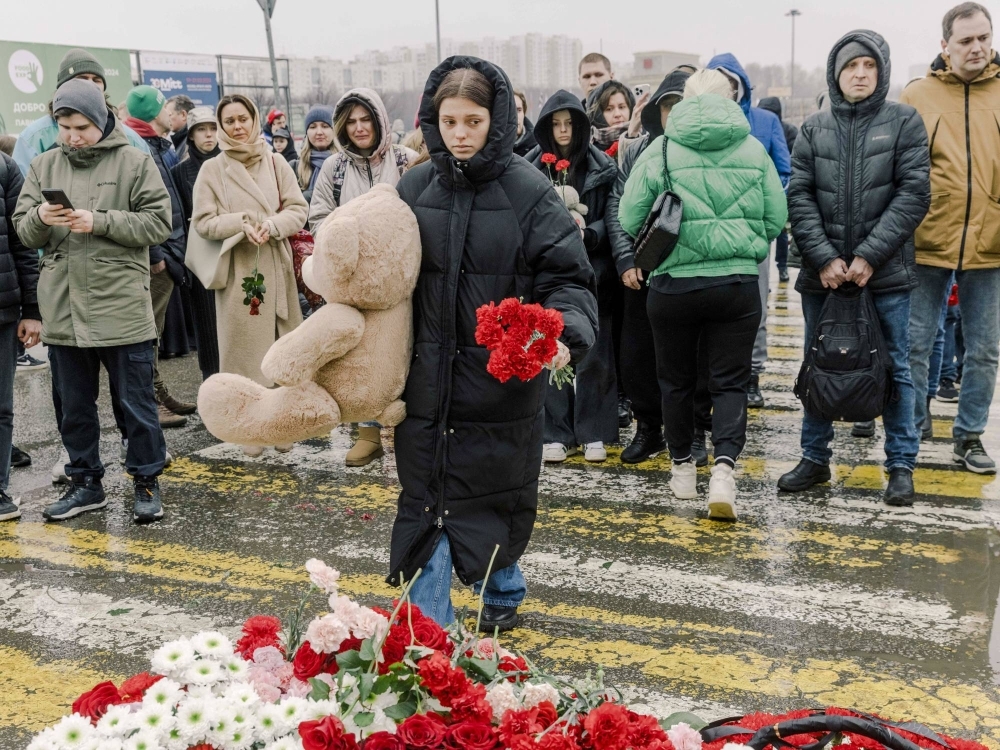 People lay flowers at a makeshift memorial near Crocus City Hall, a concert venue outside Moscow that was the site of a mass shooting on Friday night. 
