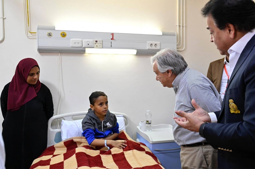 U.N. Secretary-General Antonio Guterres meets with a Palestinian child evacuated from the Gaza Strip at a hospital in El-Arish, Egypt, on Saturday. 