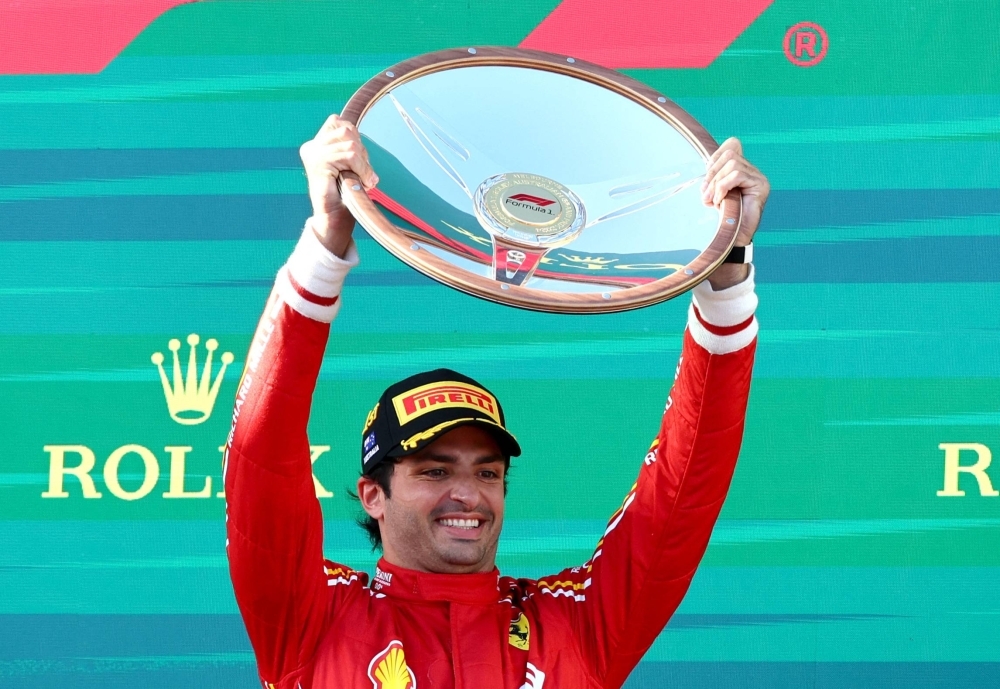 Ferrari's Carlos Sainz celebrates with the winner's trophy after taking the Australian Grand Prix on Sunday in Melbourne. 