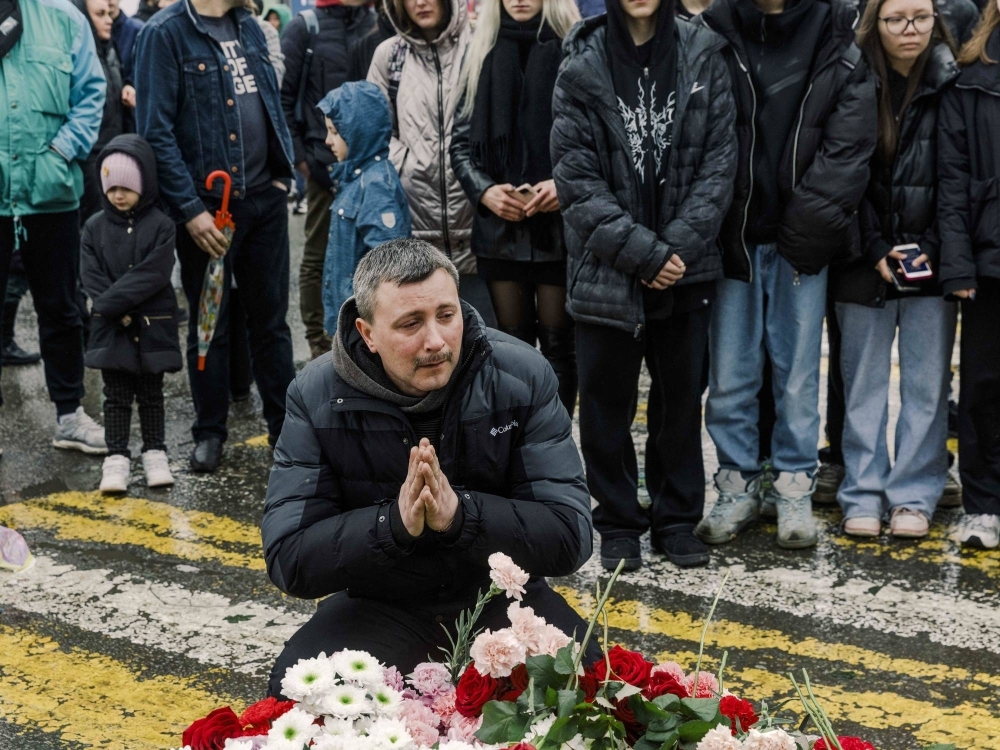 People lay flowers at a makeshift memorial Saturday near the Crocus City Hall, a popular concert venue where more than 130 people were killed Friday night in an attack outside Moscow.
