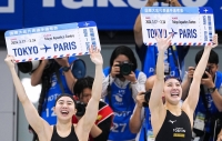Japanese swimmers Yui Ohashi (right) and Shiho Matsumoto celebrate after qualifying for the Paris Olympics in the women's 200-meter individual medley at the selection trials at Tokyo Aquatics Centre on Sunday. | Kyodo
