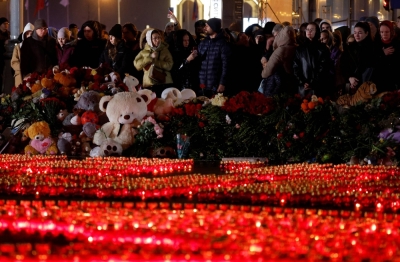 People gather near lit candles outside the Crocus City Hall concert venue on Sunday, declared a day of mourning declared following a deadly shooting, in the Moscow Region, Russia.