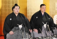 Sumo wrestler Kotonowaka (left) attends a news conference in Matsudo, Chiba Prefecture, on Jan. 31. Sitting next to him is his father and stablemaster Sadogatake. | Pool / via Kyodo

