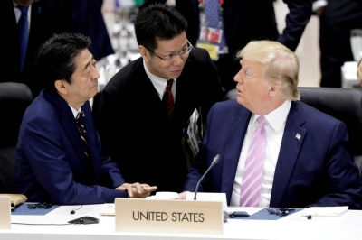 Sunao Takao (center) interprets as then-Prime Minister Shinzo Abe and U.S. President Donald Trump talk prior to a working lunch at the Group of 20 summit in Osaka on June 28, 2019.