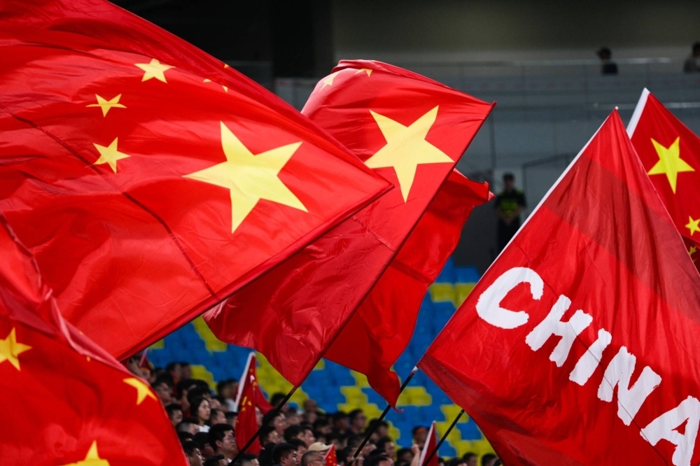 Fans wave Chinese national flags during an international friendly match between China and Syria, in Chengdu, China, in 2023.