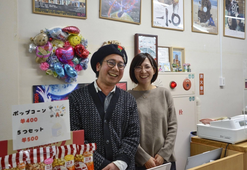 Hiroaki Wada (left), the director of Shimane Cinema Onozawa, and his wife, Sarasa, stand in an area selling snacks. 