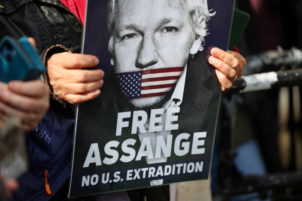 A supporter of WikiLeaks founder Julian Assange holds a sign in London on Tuesday. Assange's many supporters hail him as an anti-establishment hero who is being persecuted for exposing U.S. wrongdoing and alleged war crimes.