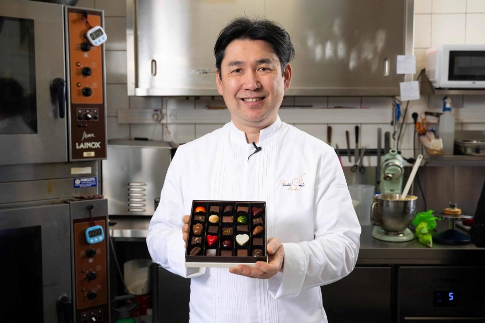 Japanese chocolatier Yasushi Sasaki holds a box of chocolates in his workshop in the Brussels commune of Woluwe-Saint-Pierre.