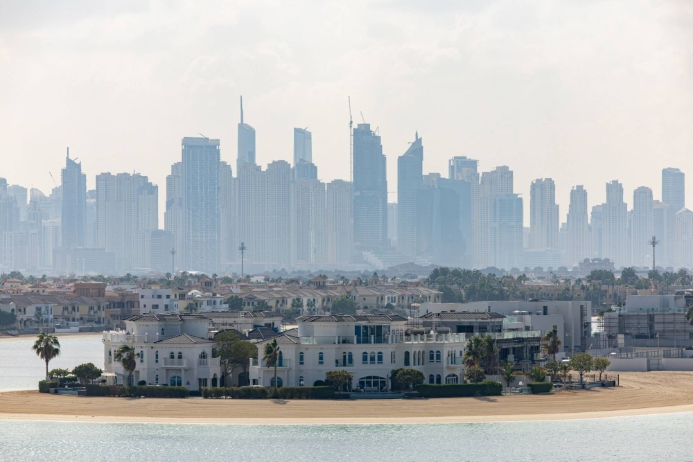 Residential skyscraper buildings beyond luxury villas on the waterfront of the Palm Jumeirah in Dubai
