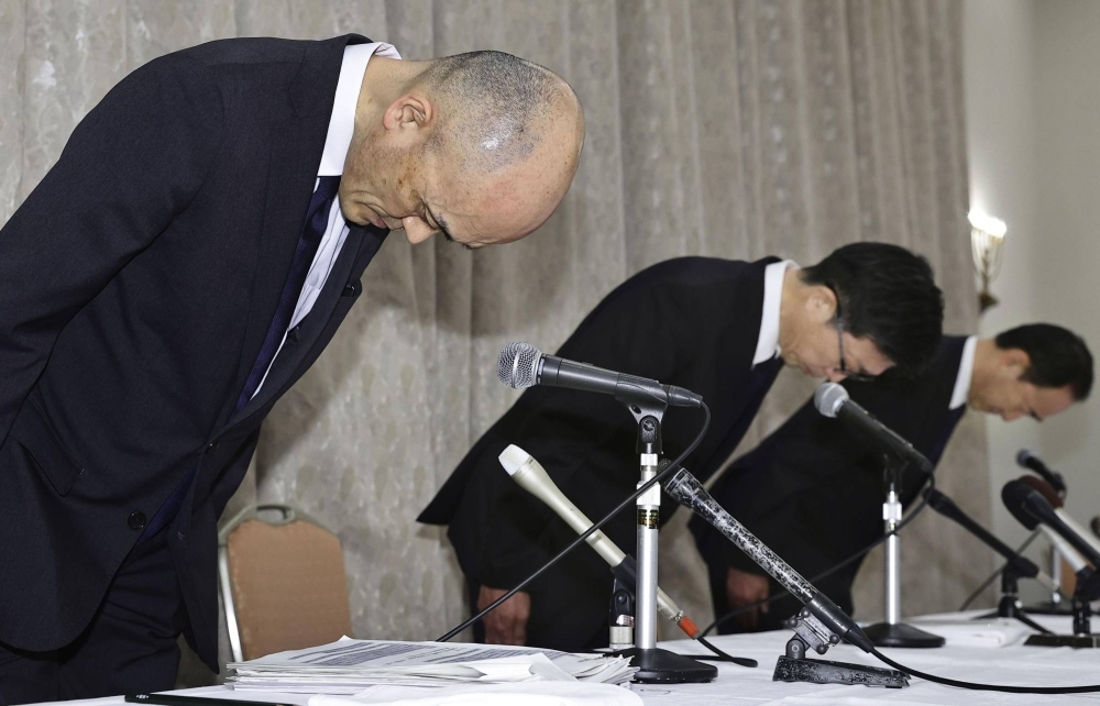 Koji Murakami, chairman of Takarazuka Revue (left), and Yasuo Shimada, the president of Hankyu Hanshin Holdings (center), apologize during a news conference in Osaka Prefecture on Thursday.
