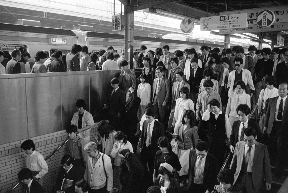 People exit the platform at a train station along the Yamanote Line in Tokyo in 1986. A time-traveling TV comedy with a bawdy middle-aged hero from the era has become a big hit in Japan, juxtaposing brash 1980s attitudes with the more politically correct present day.