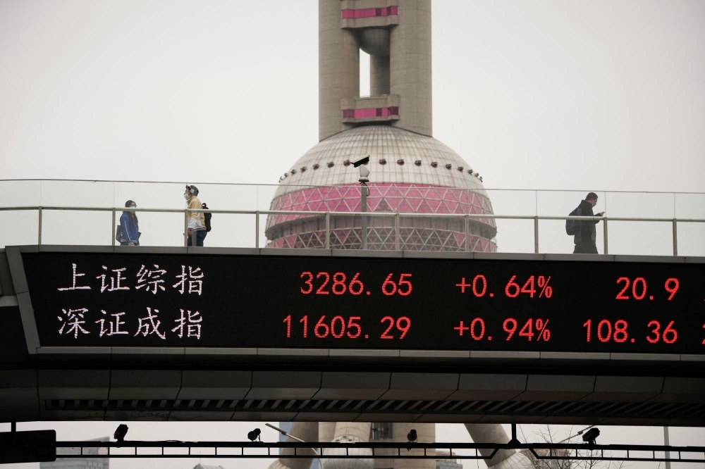 An electronic board shows Shanghai and Shenzhen stock indexes at the Lujiazui financial district in Shanghai on March 24.