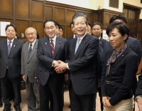 Prime Minister Fumio Kishida and Komeito leader Natsuo Yamaguchi shakes hands at the parliamentary building following the enactment of the fiscal 2024 budget on Thursday. | Kyodo