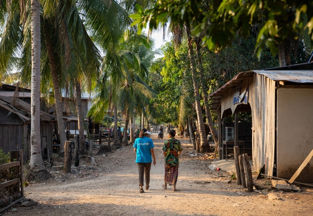 San Vansen (right), an Indigenous leader of the Kuy community in Cambodia, walks with a field officer from UNICEF in Inn Chey village in Kratie Province.