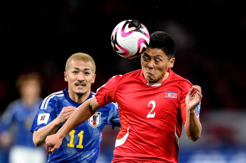 North Korean defender Kim Kyong Sok and Japan winger Daizen Maeda compete for the ball during a World Cup qualifying match on March 21 in Tokyo. 
