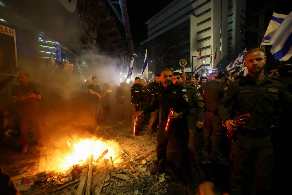 Israeli police officers hold fire extinguishers during a protest against  Prime Minister Benjamin Netanyahu's government in Tel Aviv on Saturday.