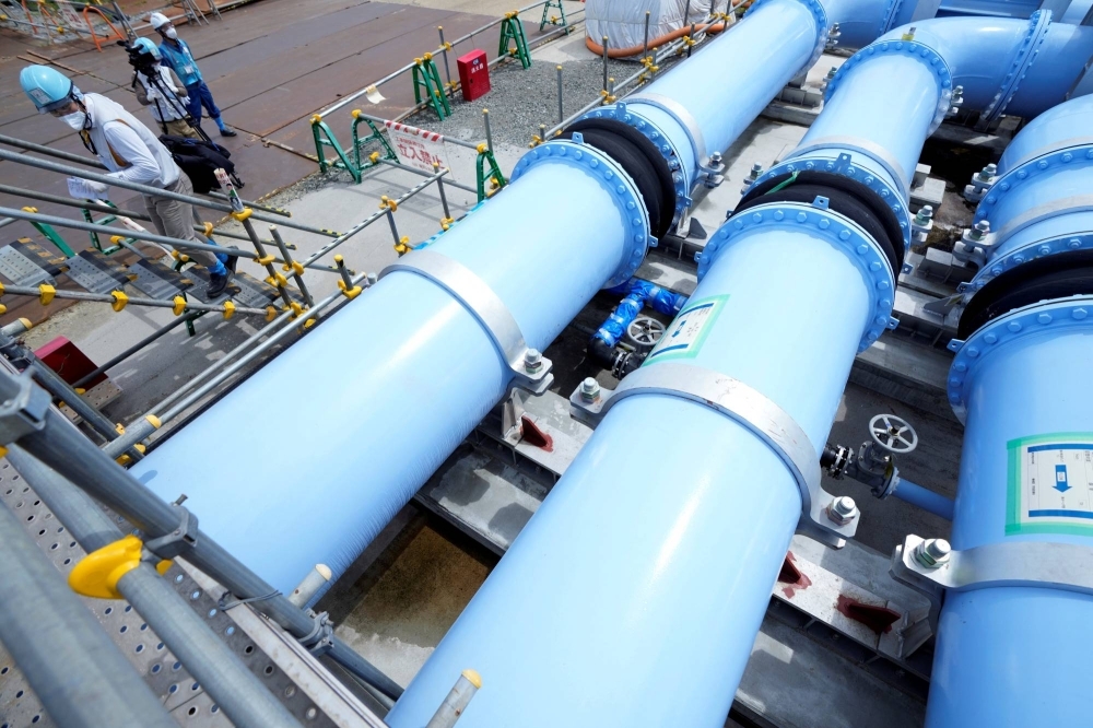 Blue pipelines to transport seawater, part of the facility for releasing treated radioactive water to sea from the Fukushima No. 1 nuclear power plant, are seen during a treated water dilution and discharge facility tour for media, in Futaba, Fukushima Prefecture, last August. 