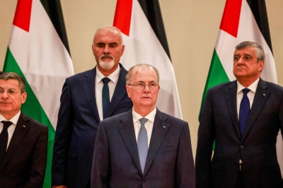 Newly-appointed Palestinian Prime Minister Mohammed Mustafa (center) poses for a picture among other ministers during a swearing in ceremony in Ramallah, in the occupied West Bank, on Sunday. A new Palestinian government that includes both Gazans and four women was sworn in Sunday, but is already facing skepticism from its own people.