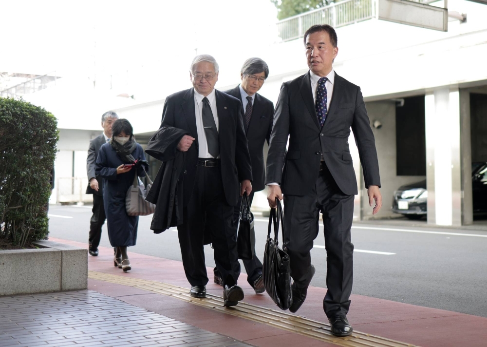 Kiichi Okaguchi (right) walks to the parliament's Judge Impeachment Court in Tokyo in December. 