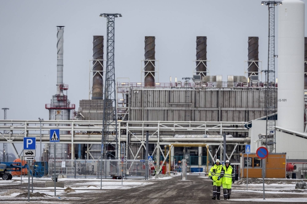 Workers walk along a road at Western Europe's largest liquefied natural gas plant Hammerfest LNG in Hammerfest, Norway